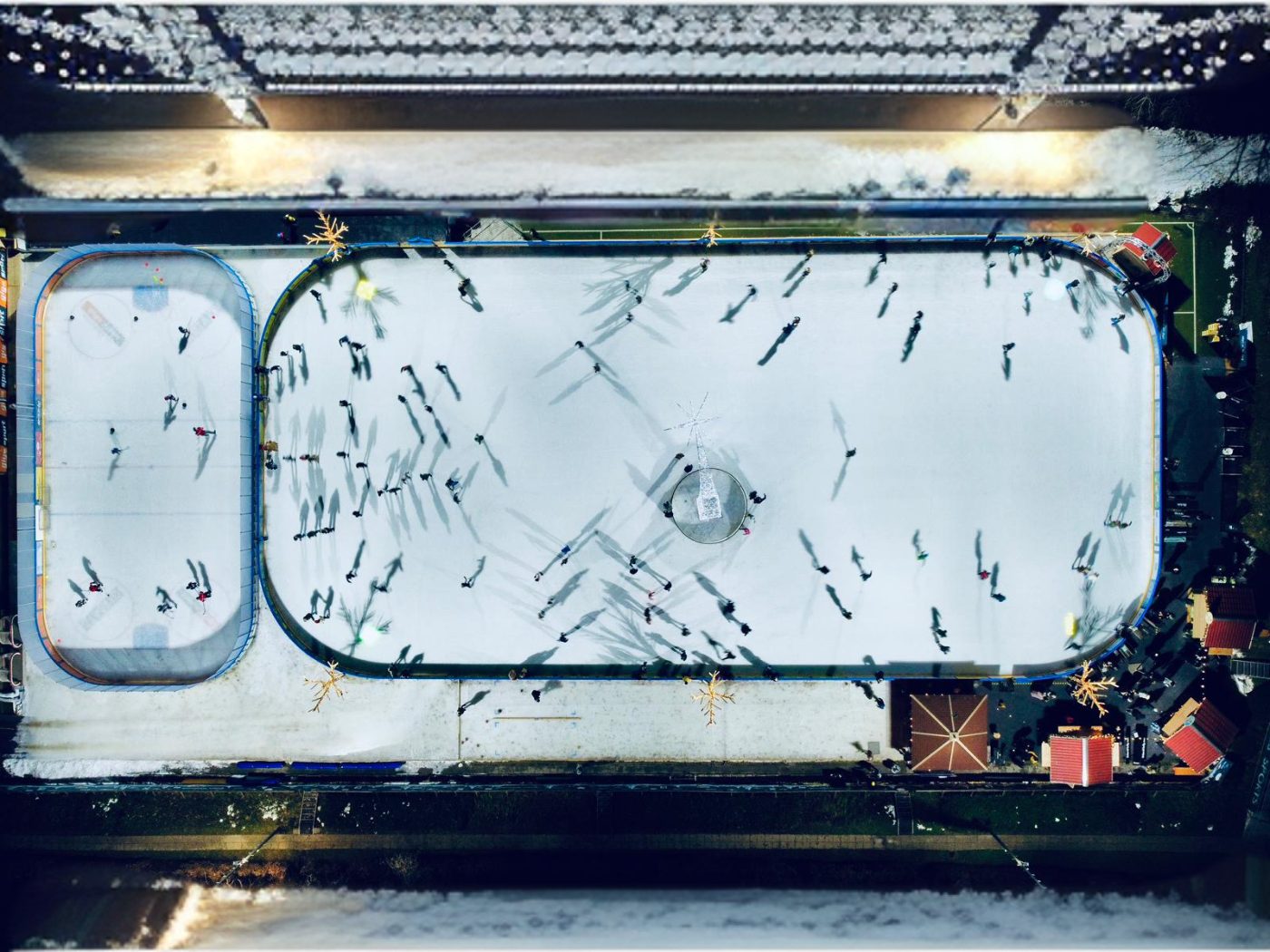 Outdoor stadium rink with crowd and large LED screen