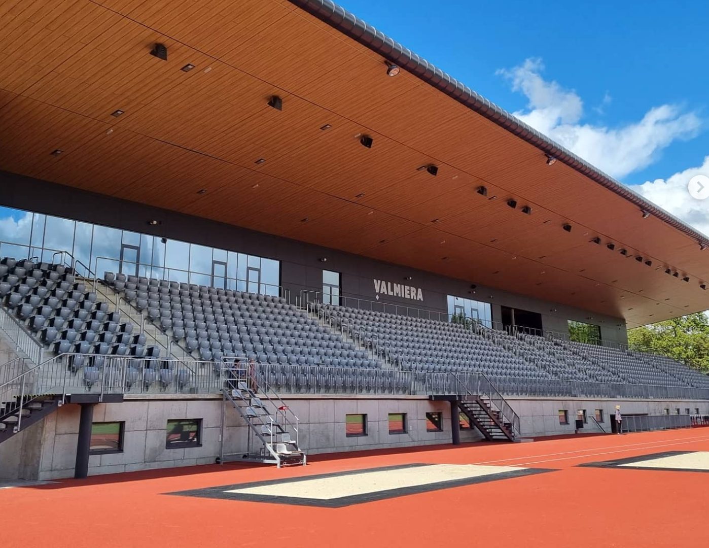 Outdoor grandstand seating at a modern covered stadium